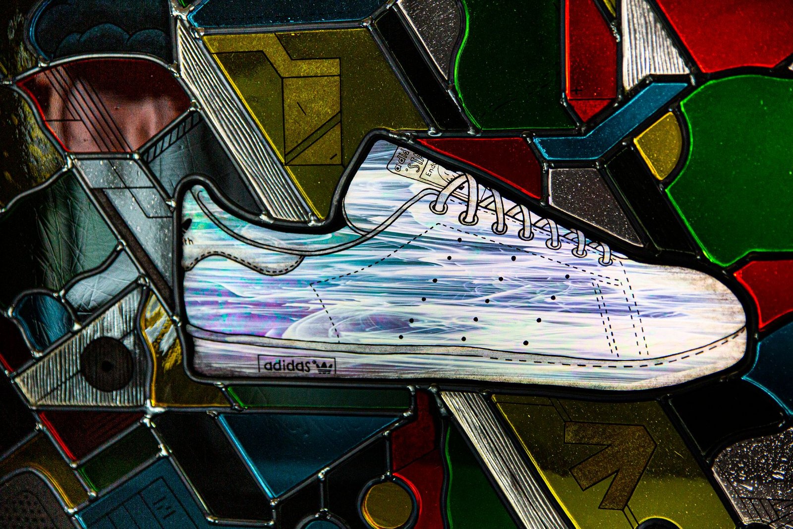 Close-up of the iridescent glass Stan Smith and the leads around it.